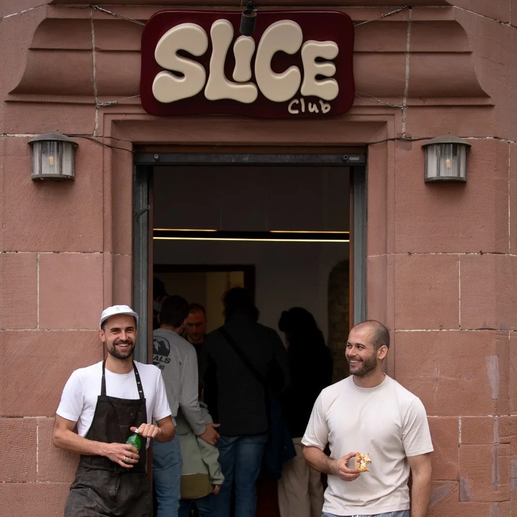 The two owners laughing in the SLICE CLUB doorway
