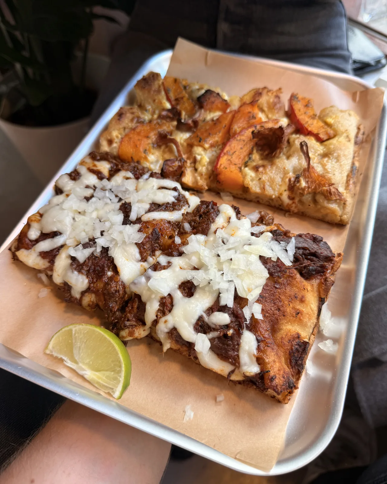 Tray in hand with braised beef, onions and lime and a slice of pumpkin with feta and chanterelles